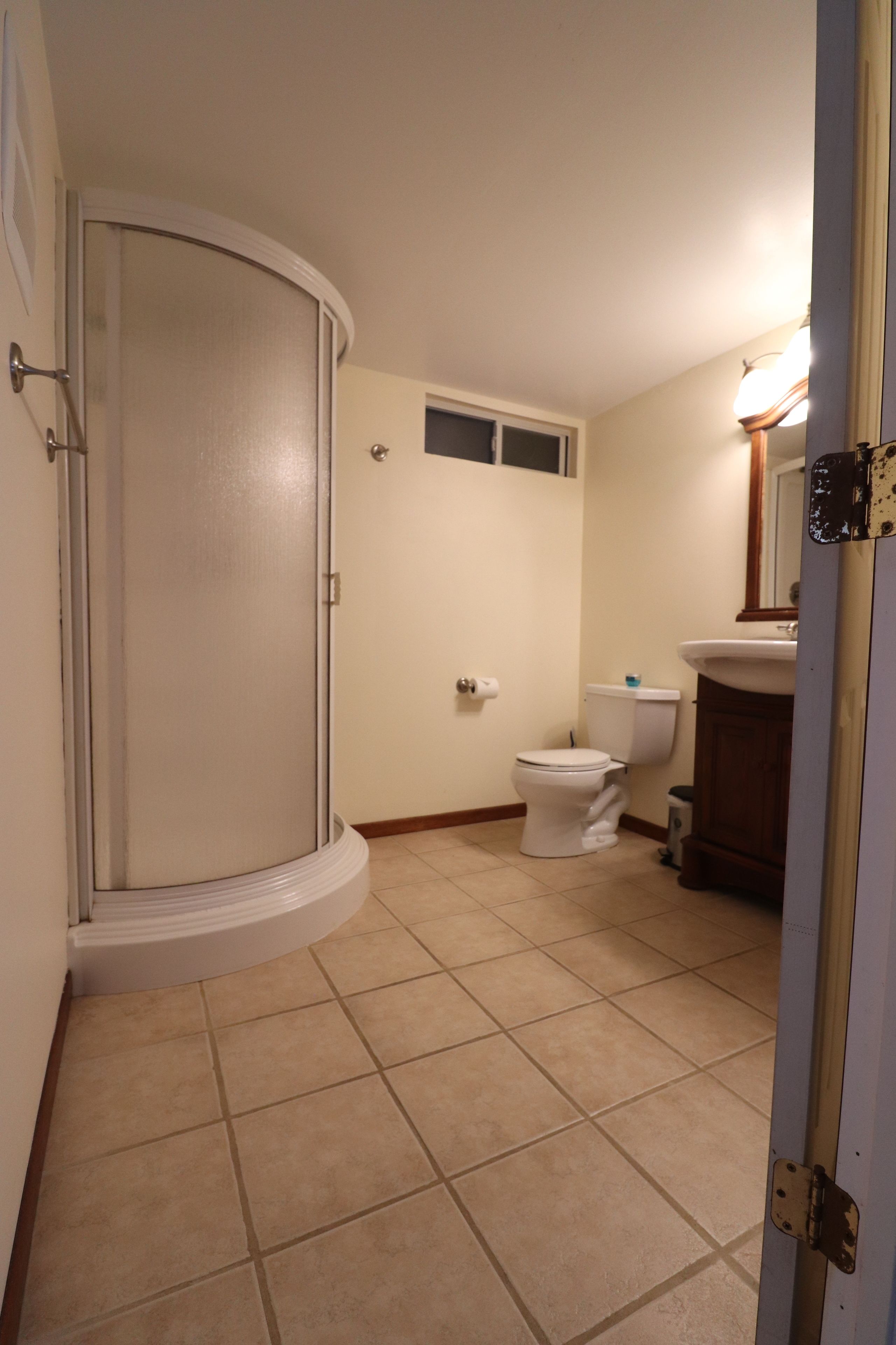 A bathroom with a shower, toilet, and sink.