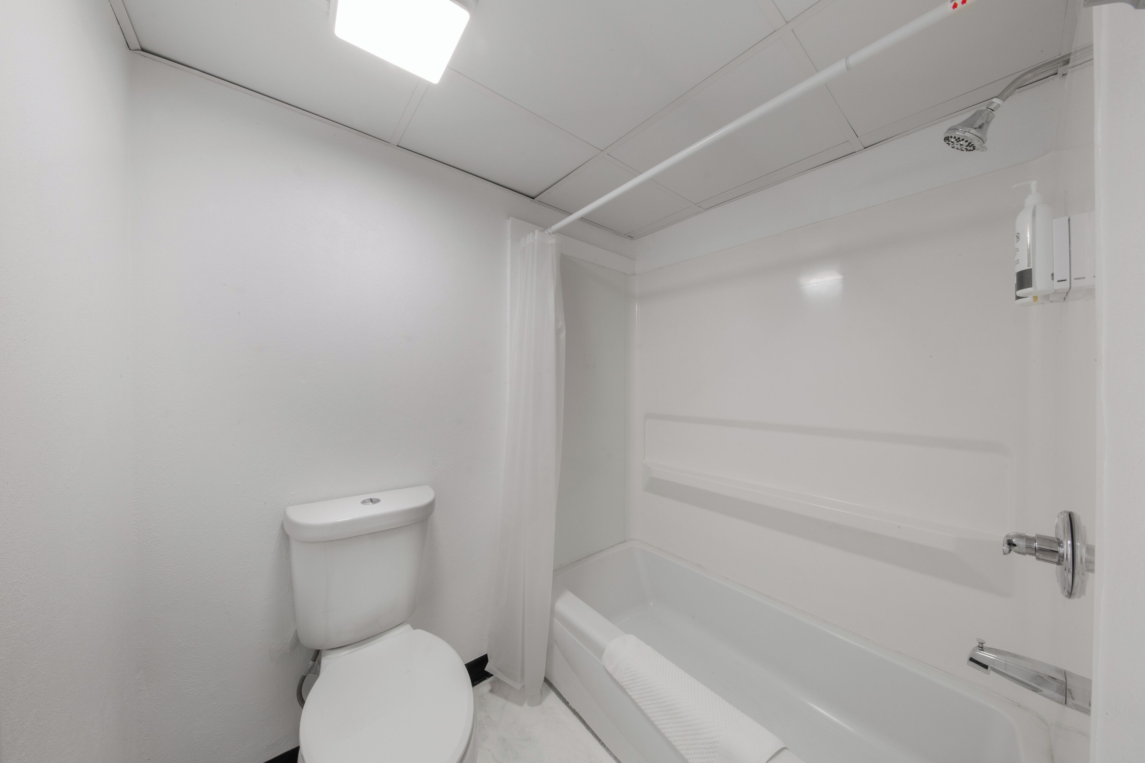 Une salle de bain avec des toilettes, une douche et une baignoire.