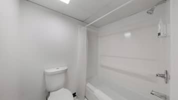 Une salle de bain avec des toilettes, une douche et une baignoire.