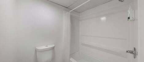 A bathroom with a toilet, a shower, and a bathtub.