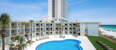 Un hotel con piscina, vista al mar y varios balcones.