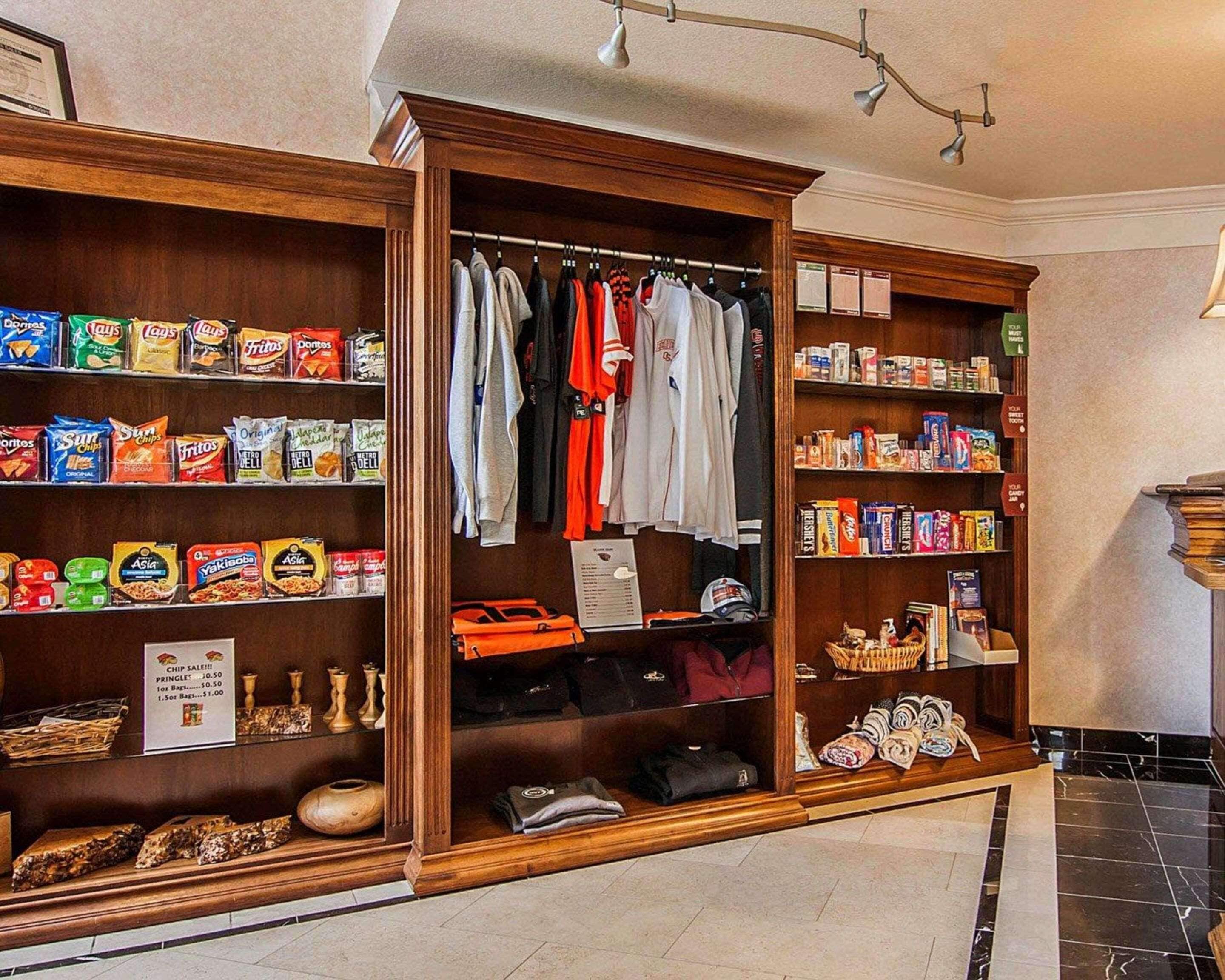 Un hall de hotel con una barra de aperitivos, percheros de ropa y una exposición de zapatos.