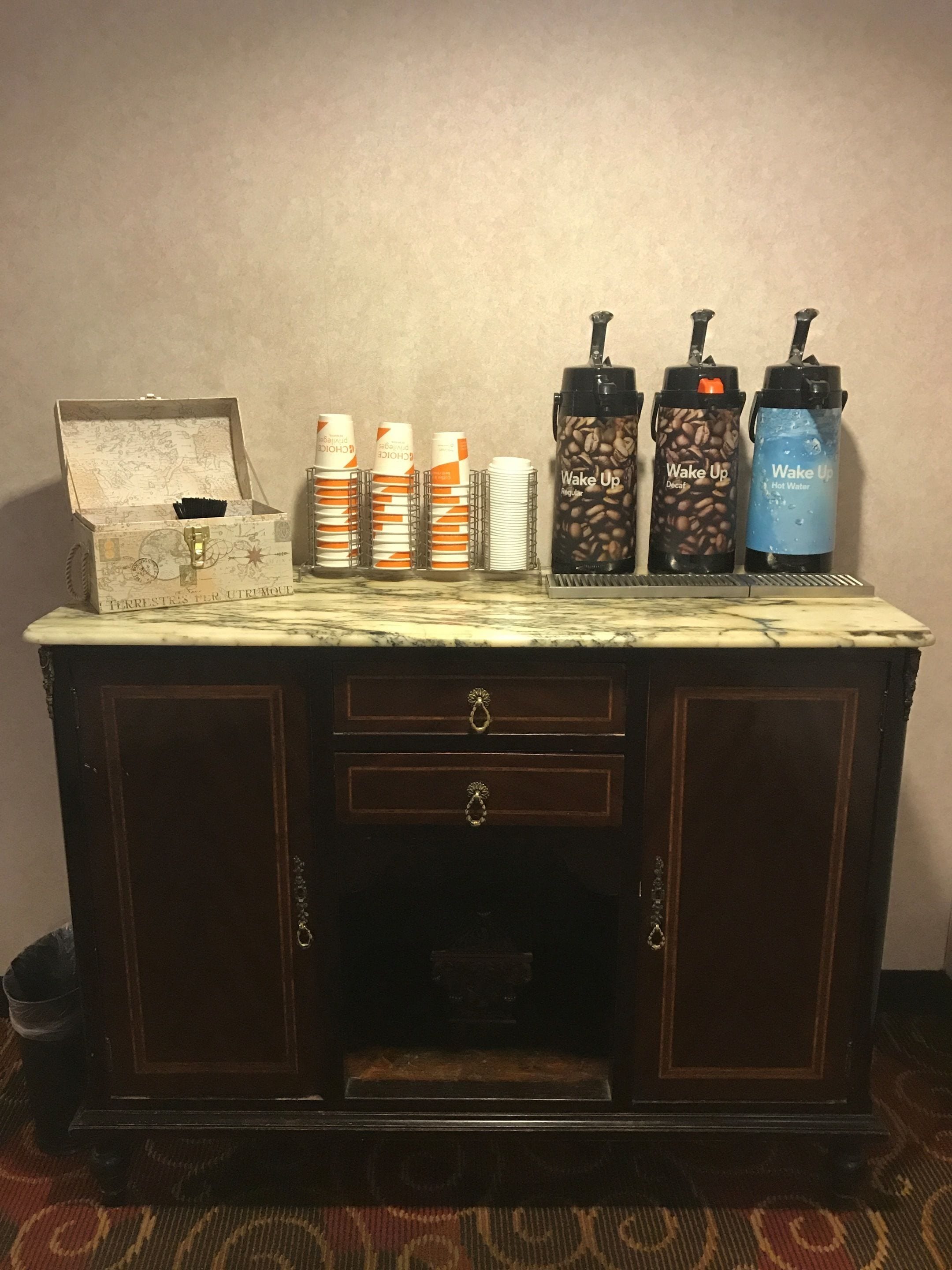 A marble-top kitchen counter with a coffee maker, a coffee grinder, and a water dispenser.