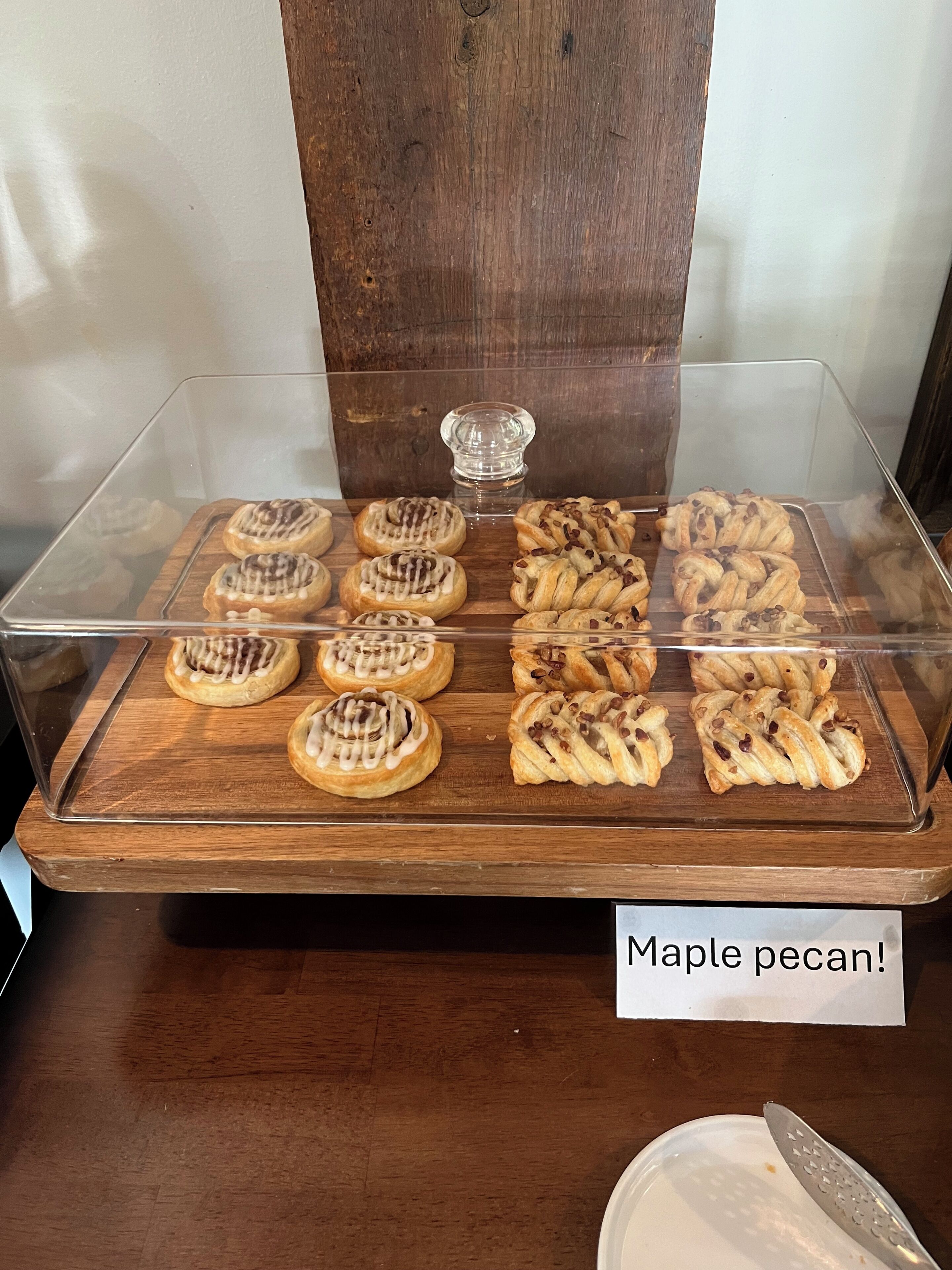 Una vitrina con varios pasteles, incluyendo pecanas con arce.