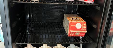 A refrigerator stocked with various dairy products including yogurts and milk.