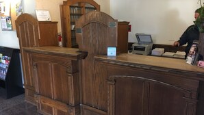A reception desk with a wooden finish, a computer, and a printer. - Hotel St. Lauren (Avalon)