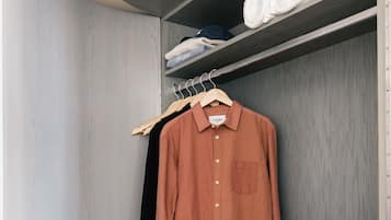 Un armadio con un attaccapanni, una camicia piegata e una valigia.