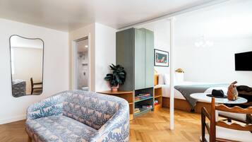 Relax in this stylish space with a large sofa, dining table, and potted plant.