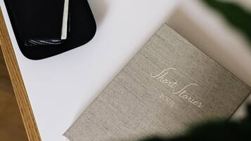 A black box with a watch and a pen, a marble vase, and a book titled "Short Stories" on a white surface.