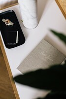Una scatola nera con un orologio e una penna, un vaso in marmo e un libro intitolato 