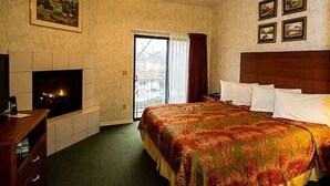 Quarto de hotel com cama, lareira, ventilador de teto e janela com cortinas.