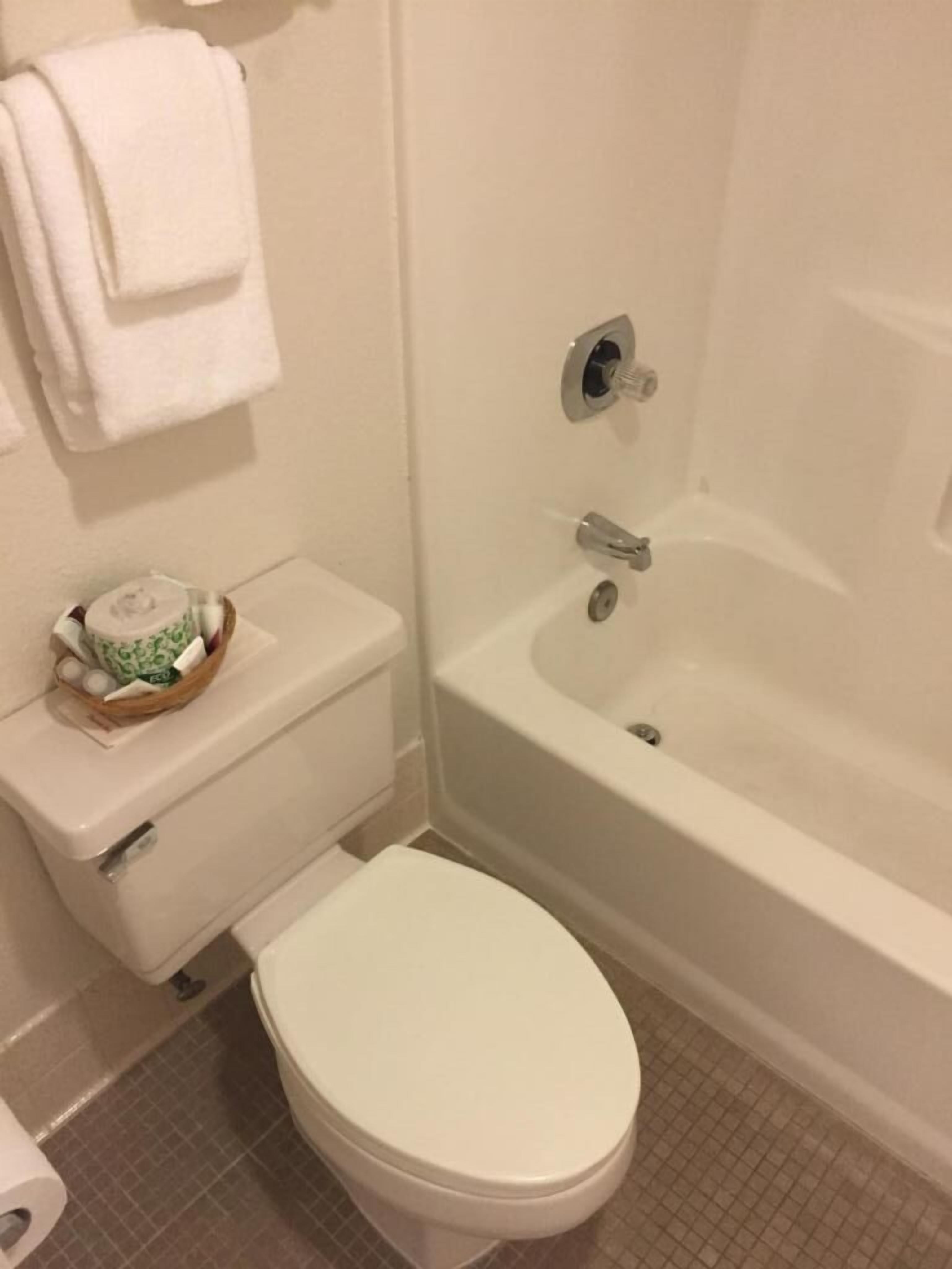 Un baño con inodoro, lavamanos blanco y bañera.