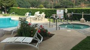 Uma área de piscina com espreguiçadeiras e um pequeno jardim.