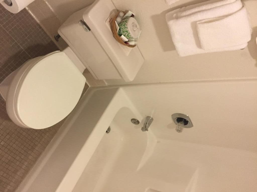 A bathroom with a toilet, a bathtub, and a towel rack.