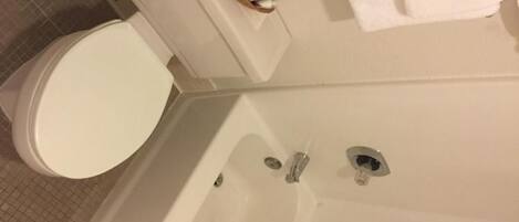A bathroom with a toilet, a bathtub, and a towel rack.