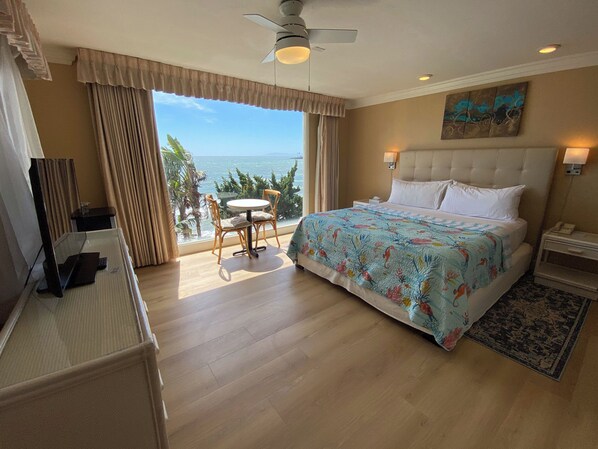 Ein Hotelzimmer mit Bett, Schreibtisch, Stuhl und Meerblick.