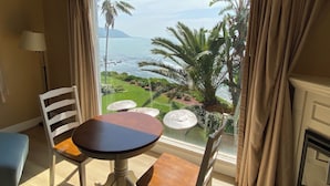 A room with a balcony, a table, and two chairs. - Cliff House Inn On The Ocean (Ventura)