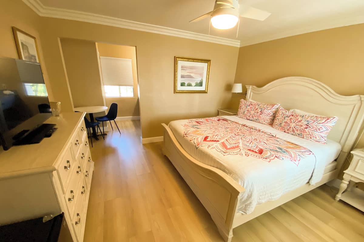 A bedroom with a bed, a desk, and a chair.