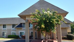 A two-story building with a symmetrical facade, large windows, and a central entrance.