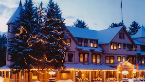 A large, multi-story hotel with a prominent Christmas tree decorated with lights, surrounded by snow. - The Wentworth (Jackson)