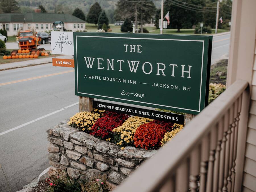 Une enseigne indiquant l’emplacement de The Wentworth, un hôtel de montagne blanc situé à Jackson, dans le New Hampshire, fondé en 1869 et proposant des formules incluant le petit-déjeuner, le dîner et des cocktails.