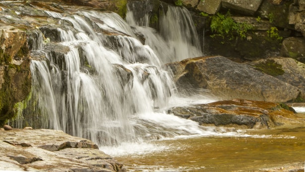 A waterfall cascading over rocks with a pool at the base. - The Wentworth (Jackson)