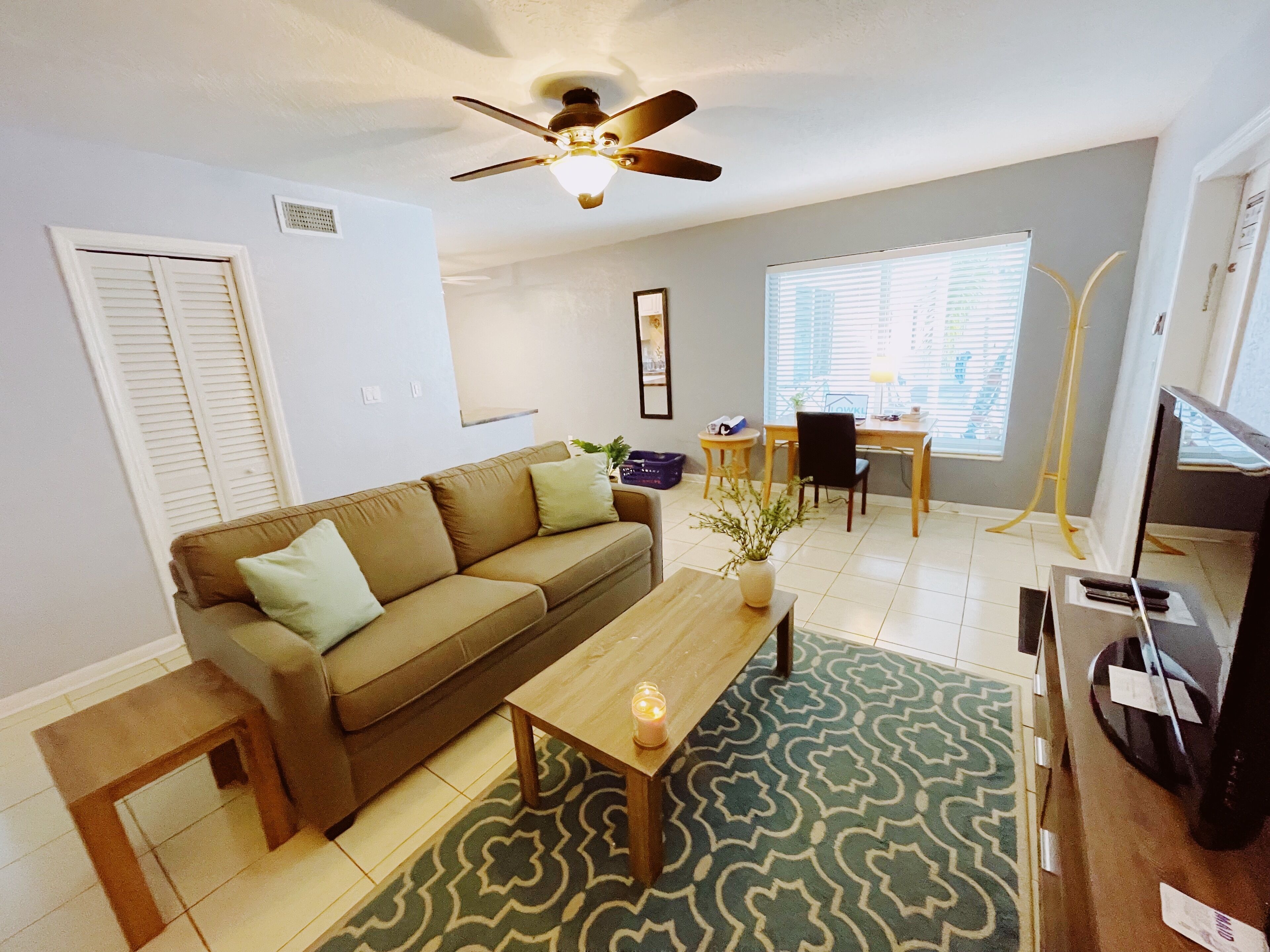 A living room with a sofa, coffee table, and a ceiling fan.