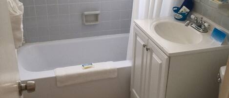 A bathroom with a bathtub, a sink, and a toilet.
