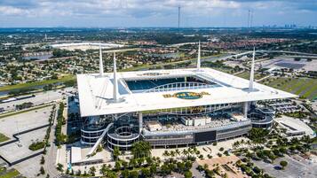Un estadio con un amplio campo central, múltiples niveles de gradas y una estructura de techo distintiva.