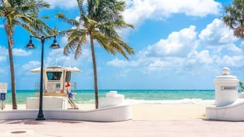 Vlak bij het strand, wit zand, parasols, strandlakens