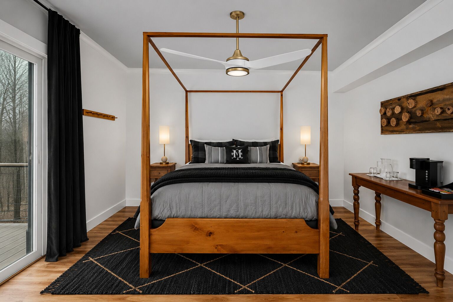 A four-poster bed with a wooden frame and a central light fixture, flanked by bedside tables with lamps, a coffee maker, and a wooden side table with a coffee pot.