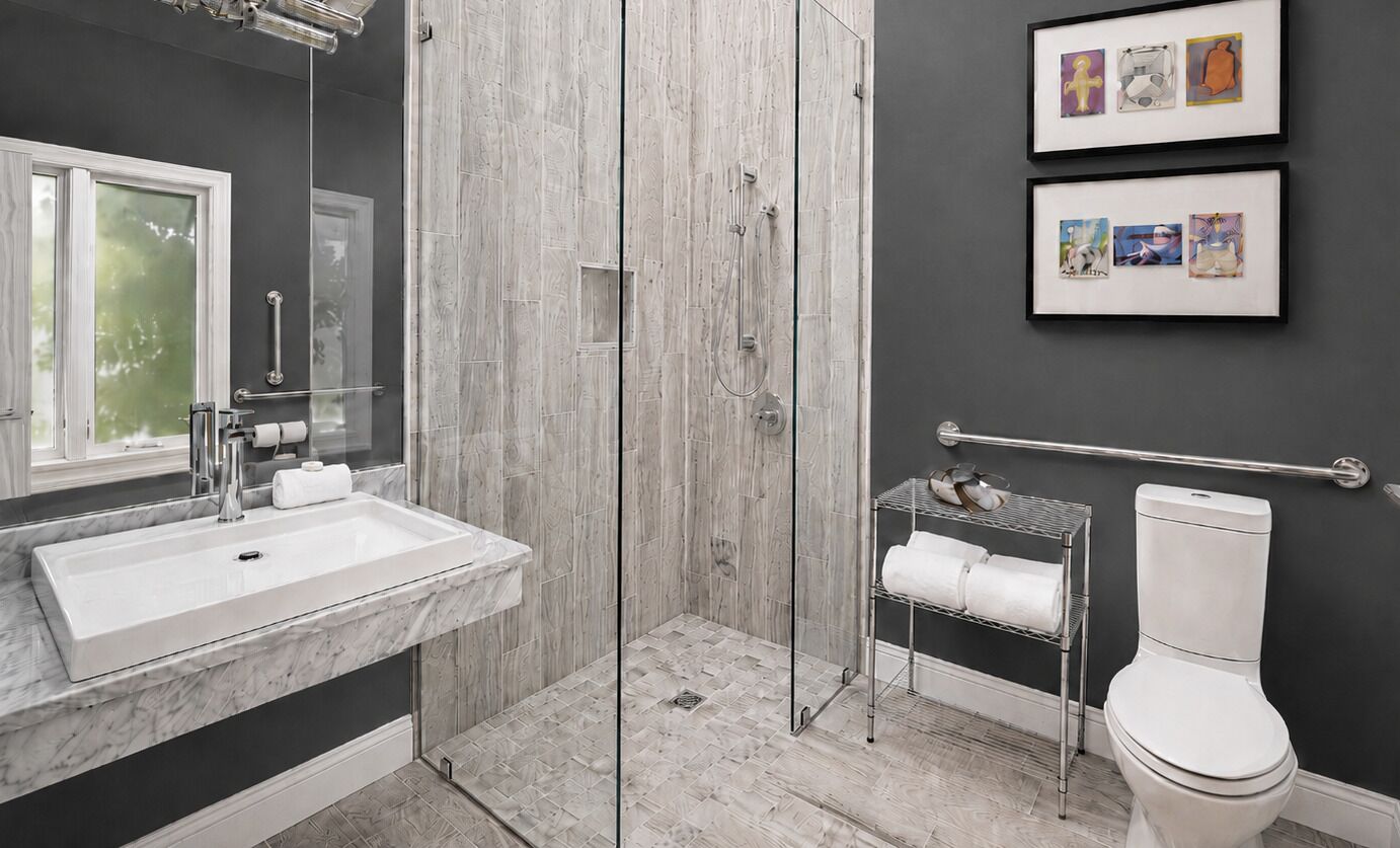 Une salle de bain moderne équipée d’une douche, de toilettes et d’un lavabo.