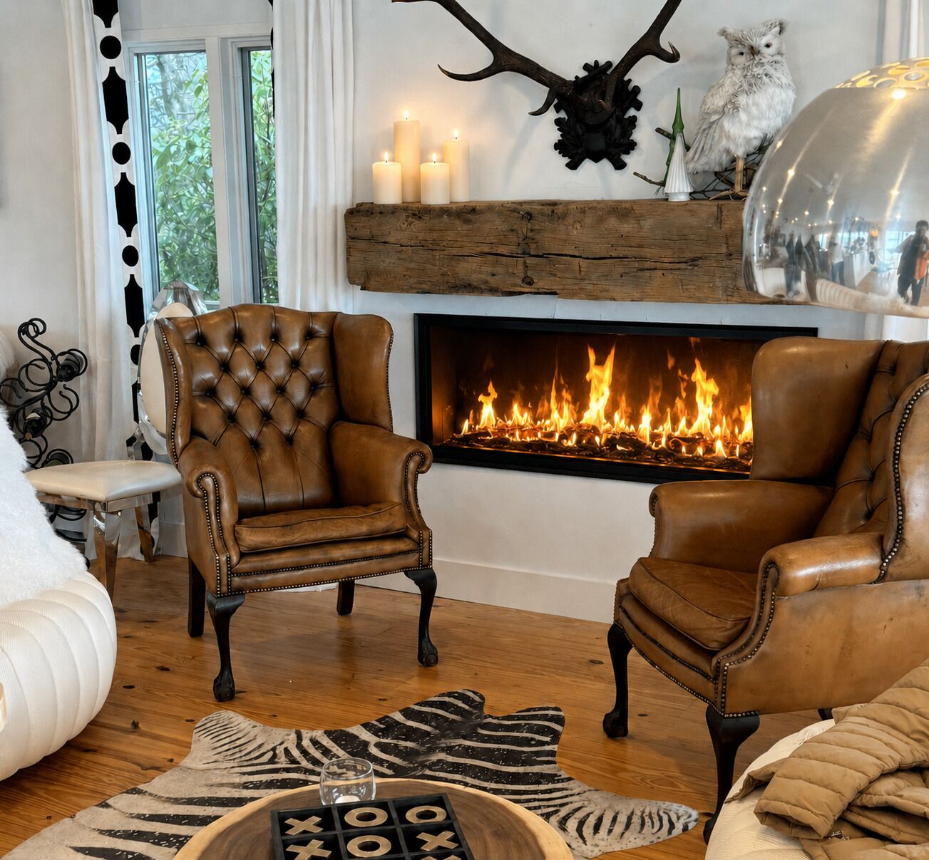 Una sala de estar con chimenea, sillones de cuero, alfombra estampada de cebra y una cúpula de vidrio.