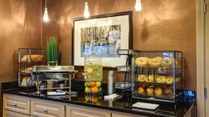 A breakfast buffet with various pastries, a fruit drink, and a framed picture on the wall. - Port Inn and Suites Portsmouth, an Ascend Collection Hotel (Portsmouth)