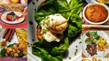 A variety of food items including a glass of Coca-Cola, a plate with spinach and poached egg, a muffin, and pancakes with blueberries.