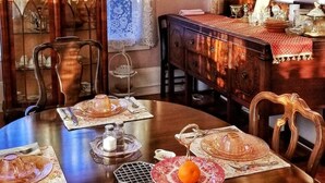 Ein Esszimmer mit Holztisch, gedeckten Plätzen, einer Pendelleuchte und einem dekorativen Spiegel.