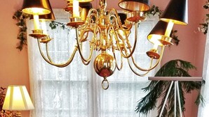 Ein Essbereich mit rosa Tischdecke, einer Kristallleuchter und einer Obstauslage.