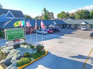 A Courtesy Inn with a parking lot, multiple flags, and a sign stating "You are amazing."