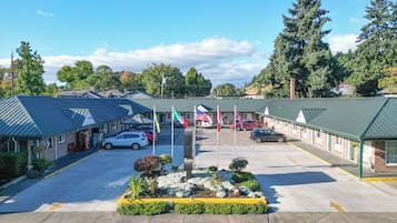 A motel with multiple rooms, a parking lot, and a landscaped garden area.