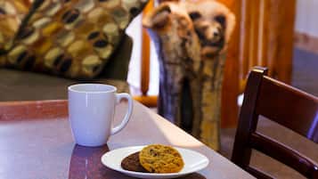 Una taza blanca y un plato con galletas sobre una mesa.