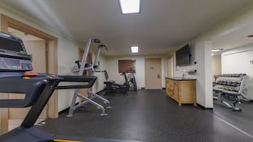 A gym with treadmills, elliptical machines, and weight equipment.