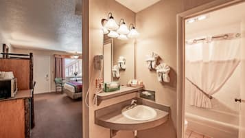 Une salle de bain d’hôtel avec un lavabo, un miroir et une douche.