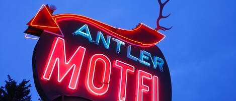 A neon sign for the Antler Motel with a deer head decoration.