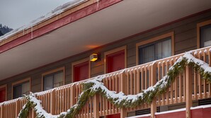 Un edificio con fachada roja, varias ventanas y un balcón con barandilla.