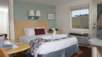 A hotel room with a bed, bedside lamps, a window, and a desk with a chair.