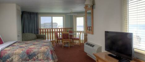 A hotel room with two beds, a TV, a desk, and a chair.