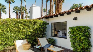 A patio with two lounge chairs, a small table, and a basket. - Ingleside Estate Hotel & Bungalows- Adults Only (Palm Springs)