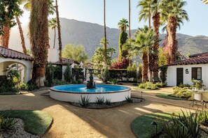 A courtyard with a central fountain, surrounded by palm trees and a mountain backdrop. - Ingleside Estate Hotel & Bungalows- Adults Only (Palm Springs)
