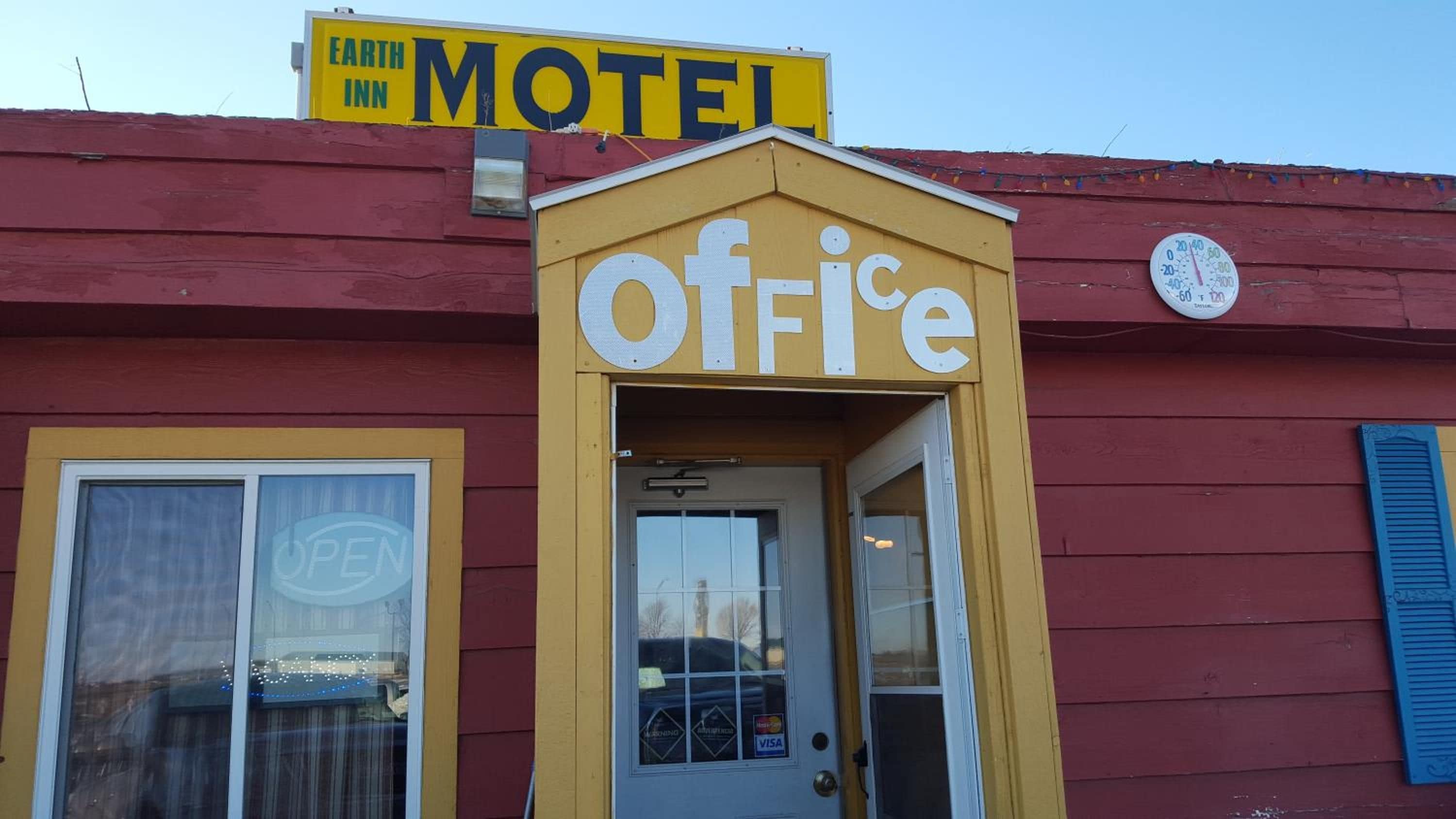 Un motel con un cartel que dice 'Motel' sobre la entrada y un cartel que dice 'fuera de servicio' en la puerta.