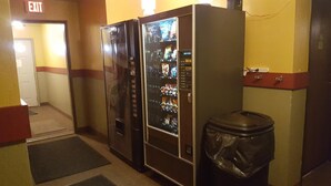A hallway with vending machines and a trash bin. - Earth Inn Motel (Jackson)